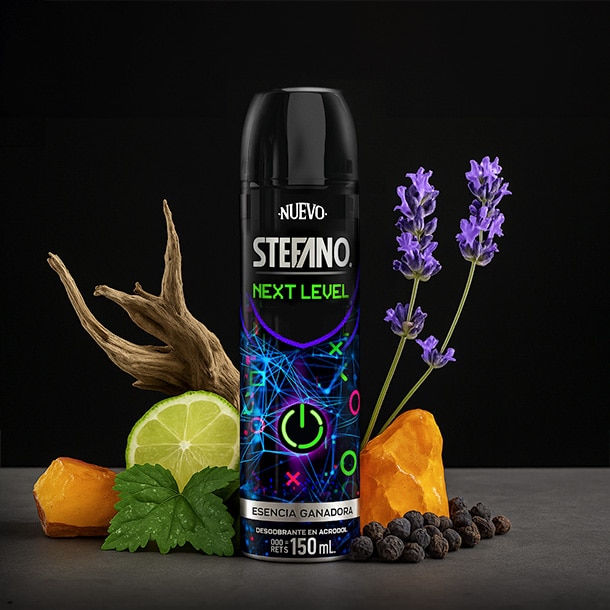 Un envase de desodorante en aerosol Stefano Next Level en el centro con un gráfico circular, acompañado de una rodaja de limón verde, flores de lavanda, ámbar y pimienta negra sobre un fondo oscuro.